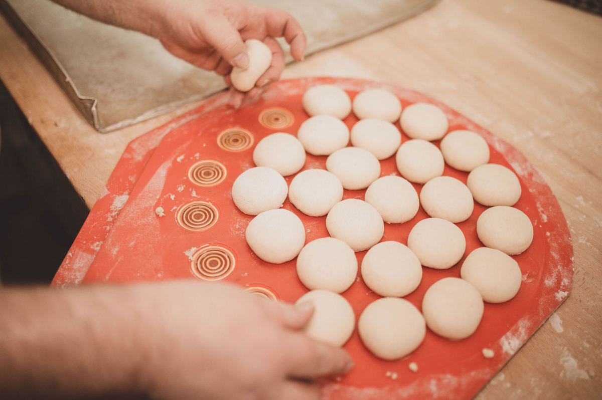 Frisch geformte Brötchen auf der roten Backmatte