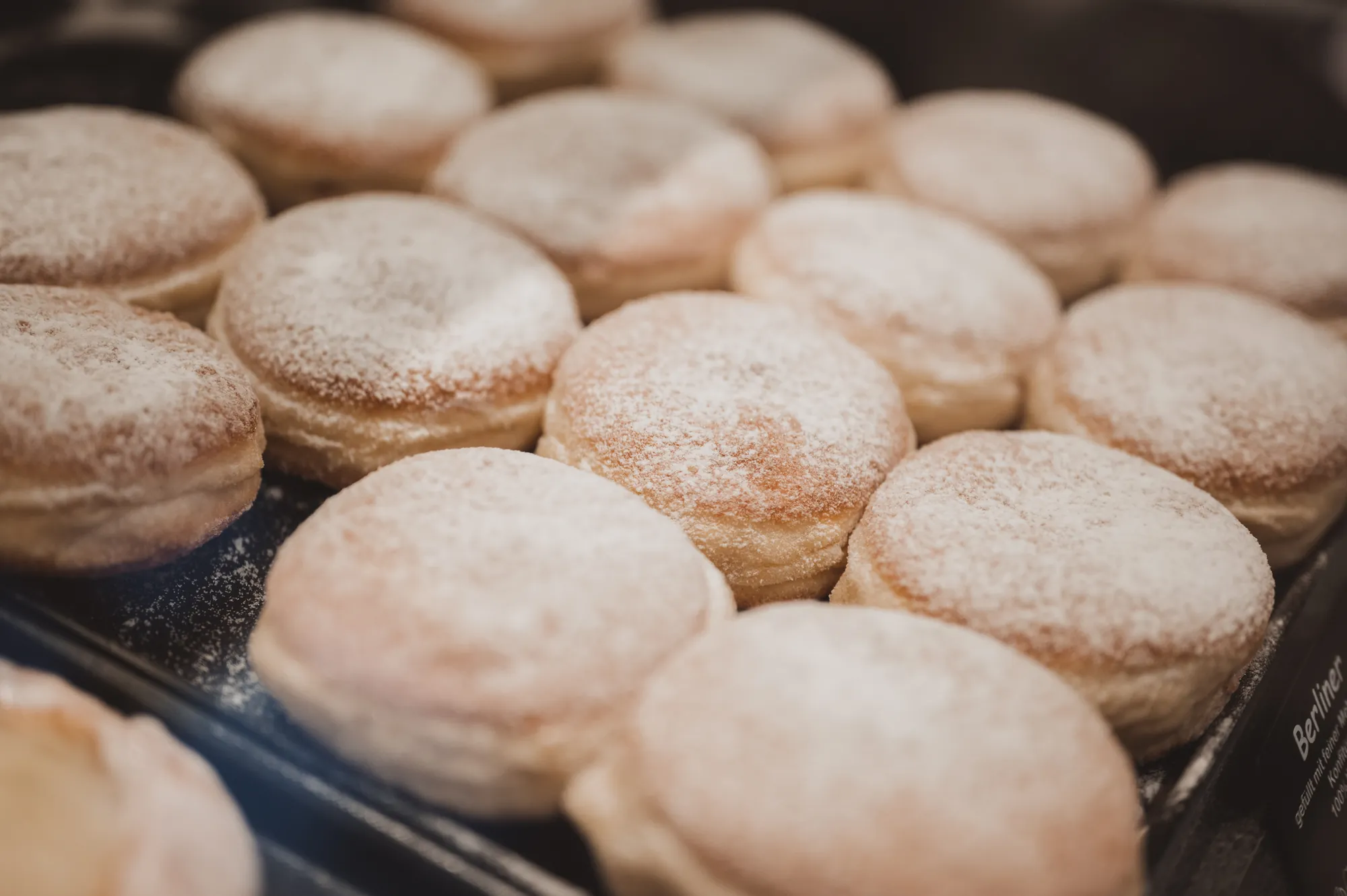 Berliner mit Puderzucker in der Verkaufstheke
