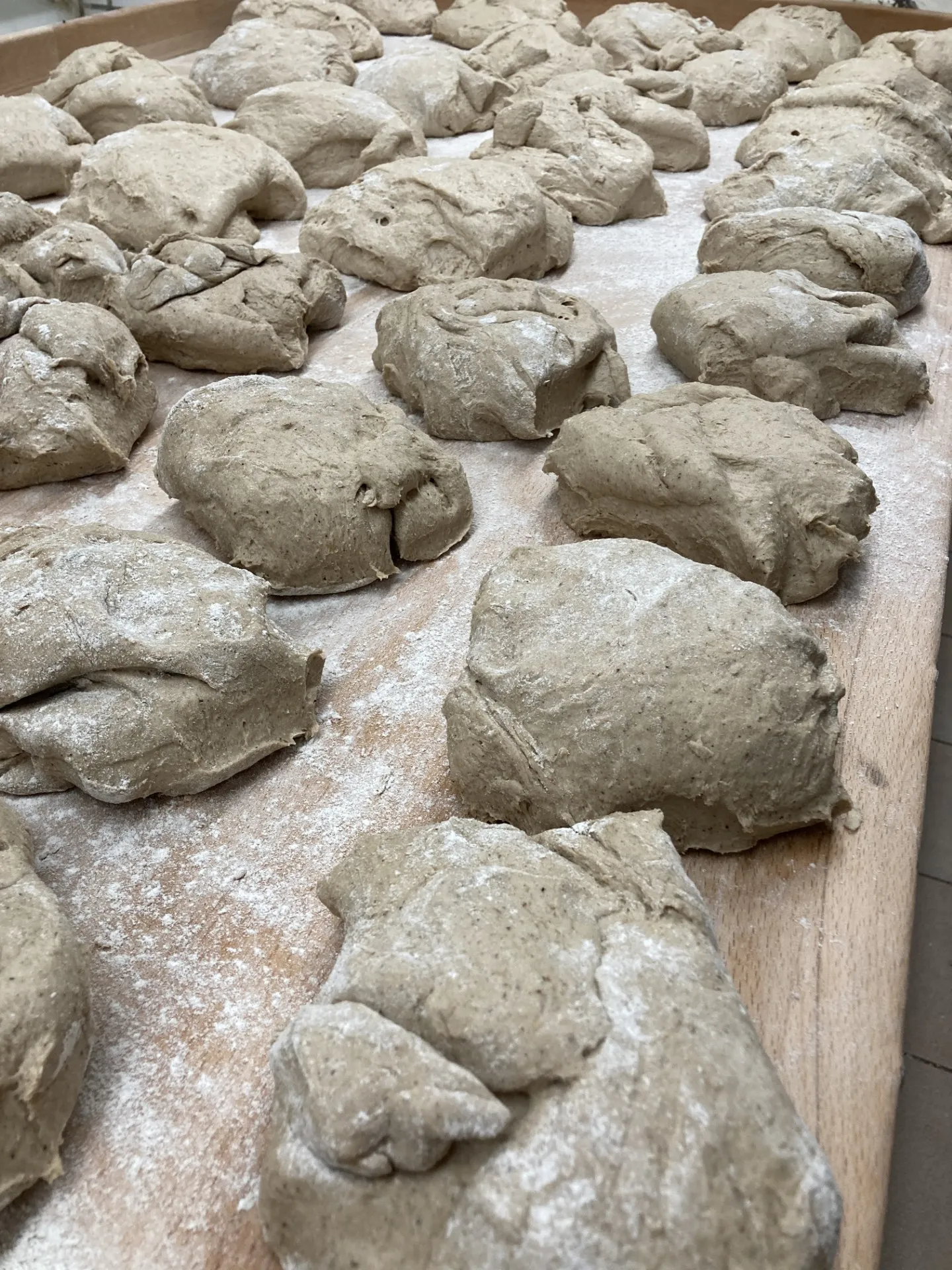 Portionierter Brotteig auf einem bemehlten Holzbrett
