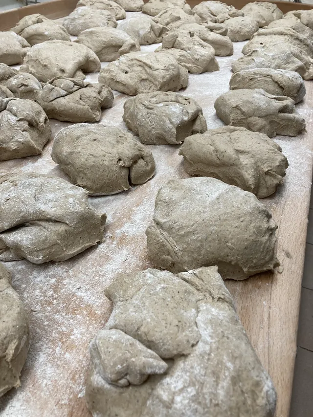 Portionierter Brotteig auf einem bemehlten Holzbrett