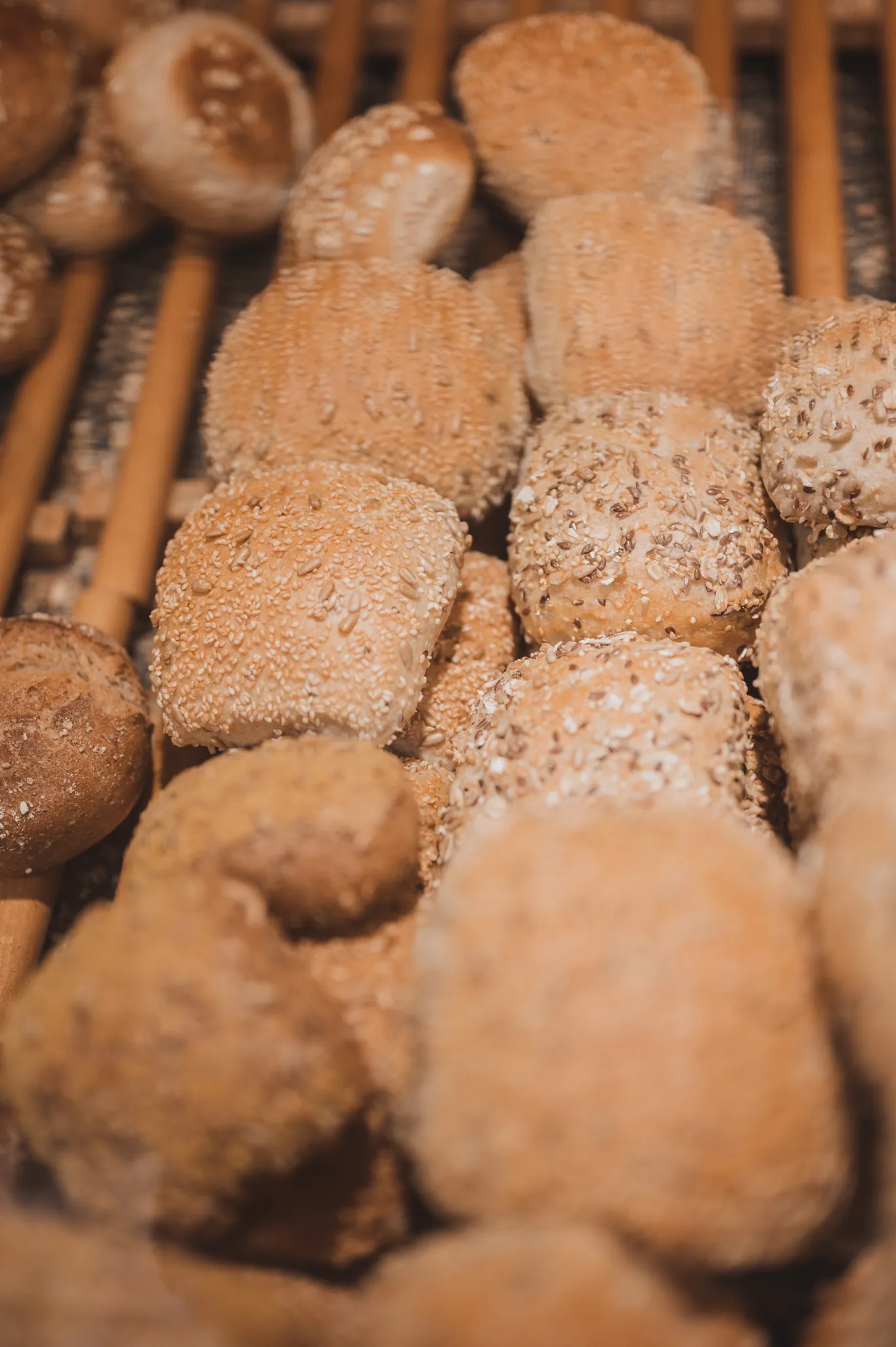 Körnerbrötchen mit Saaten im Holzrost der Verkaufstheke